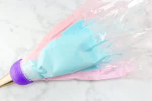 a pastry bag filled with pink and blue meringue on a counter