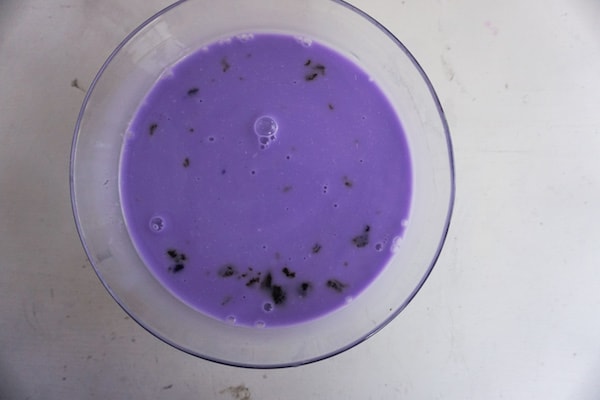 purple milk in a glass on a white table to make a dragon frappuccino