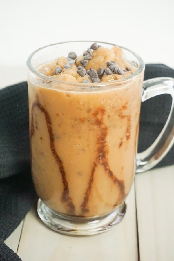 java Chip frappuccino in a glass mug on a grey wood background with a black linen