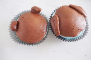 a circle of brown fondant on cupcakes with pieces of brown fondant molded to look like dog's ears