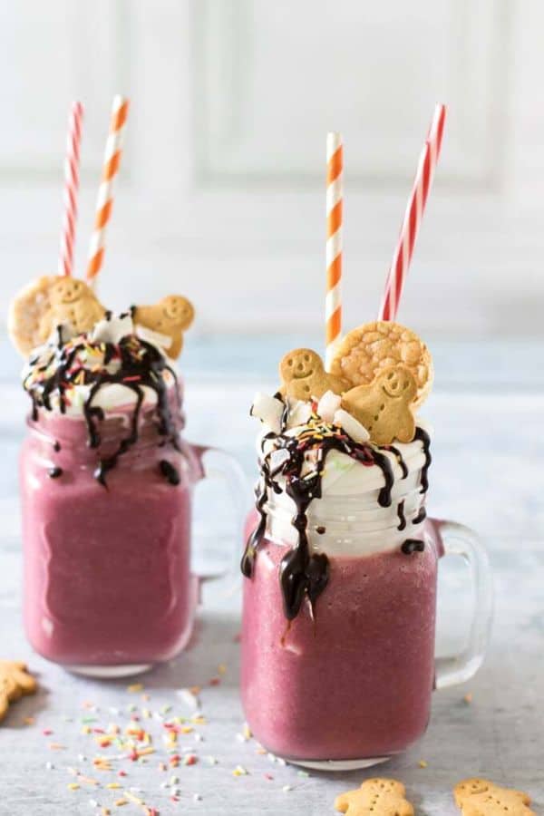 Vanilla Beet Freakshake in two glasses topped with crackers on a wood table