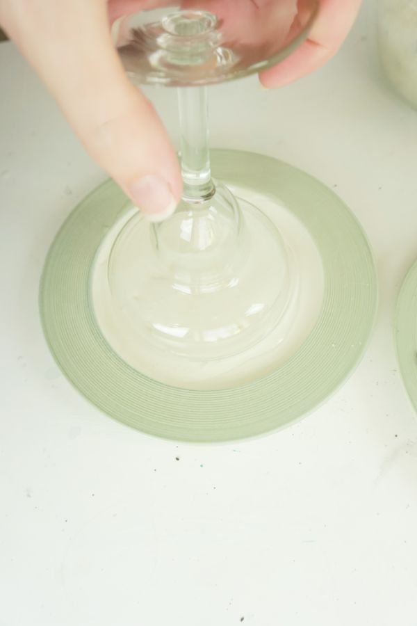 a hand pressing a glass down to put corn syrup on the rim