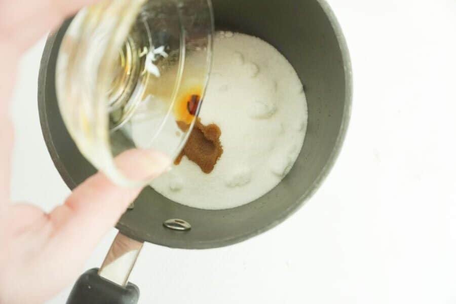 vanilla being poured into a pan of sugar and salt