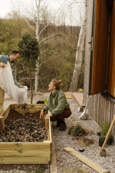 An image of a man and a woman preparing a raised garden bed.