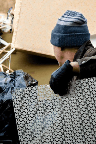 A man putting junk on a truck.