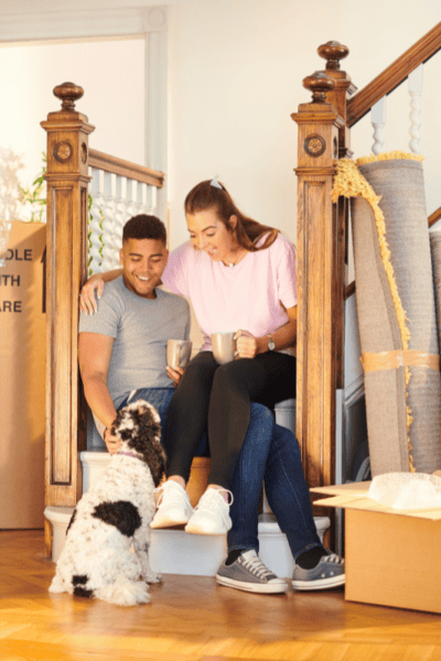 An image of a couple and their dog, moving in to their new home.